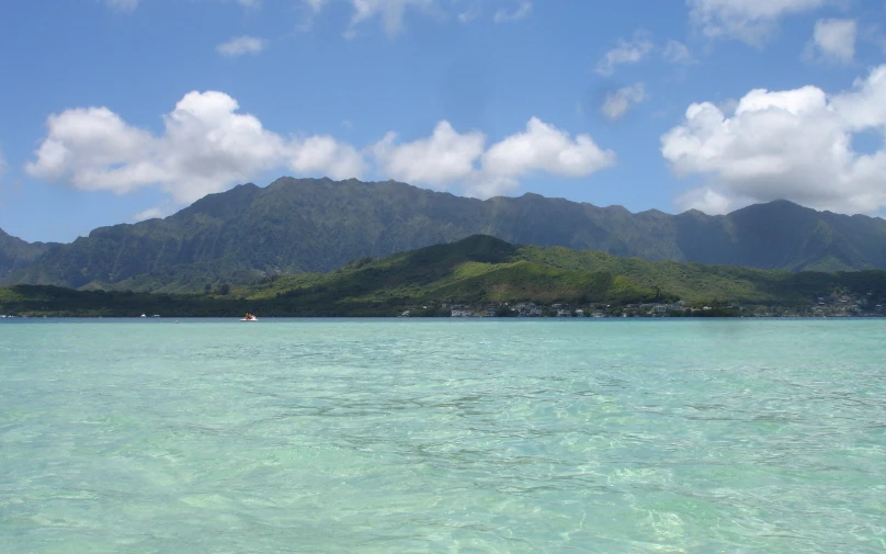 the ocean is still calm and there are boats sailing