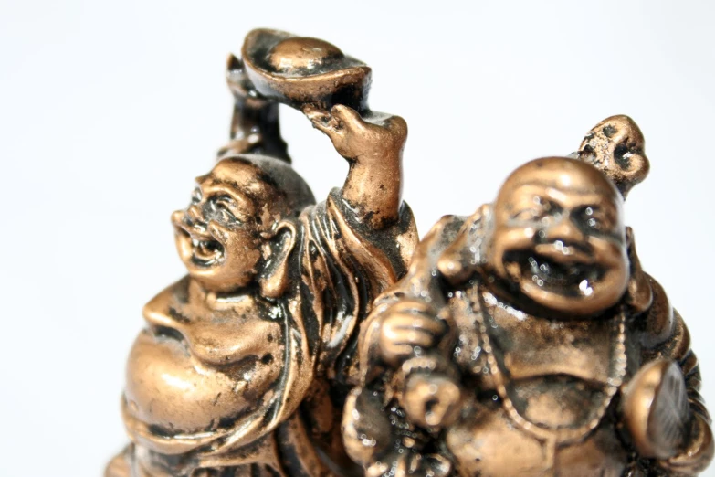 the small statues have two hands holding an object