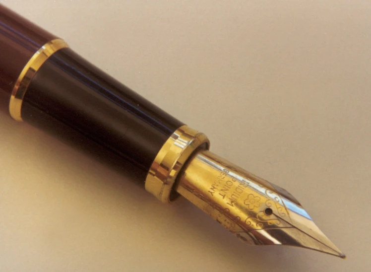 there is a pen with a gold band on it