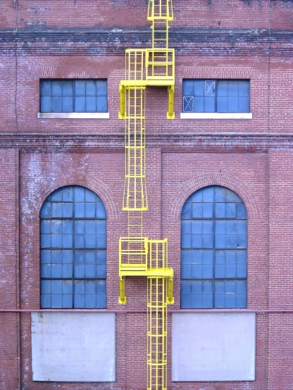 the side of an old building with a yellow fire escaper