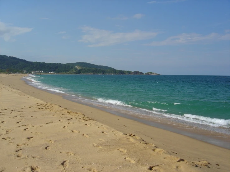 a sandy beach with waves on the shore