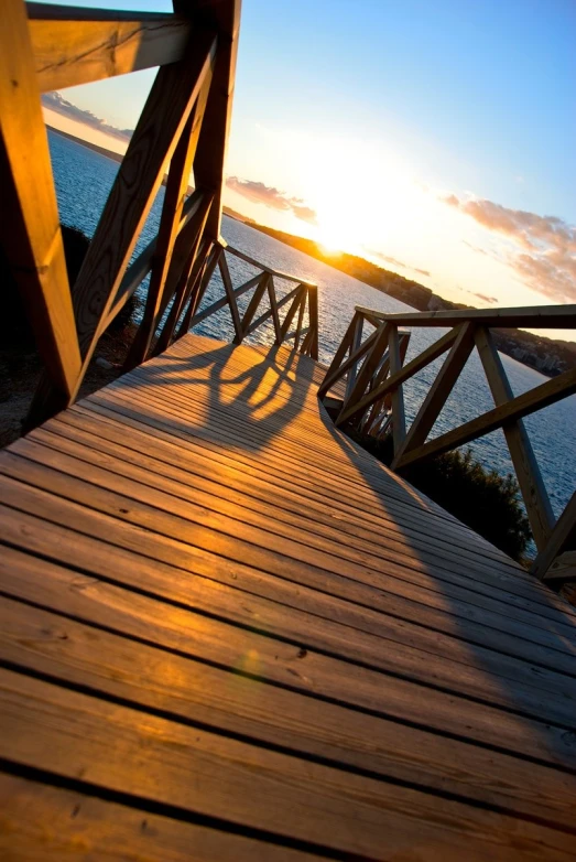 the sun is setting over the water as seen from the boardwalk