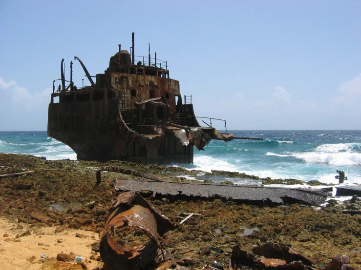 a boat is sitting on the shore with rusted parts