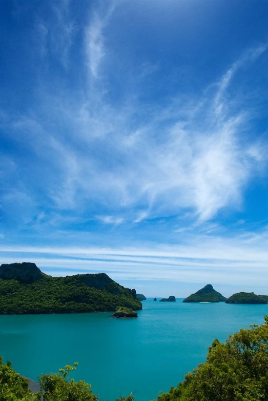 the beach is surrounded by green mountains and water