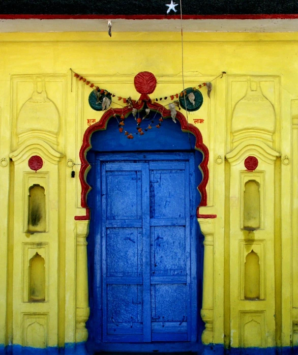 a blue door is on the side of a yellow building