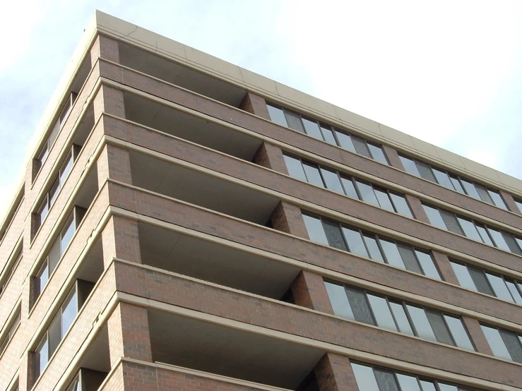 a tall brick building with windows and a stop sign attached to it