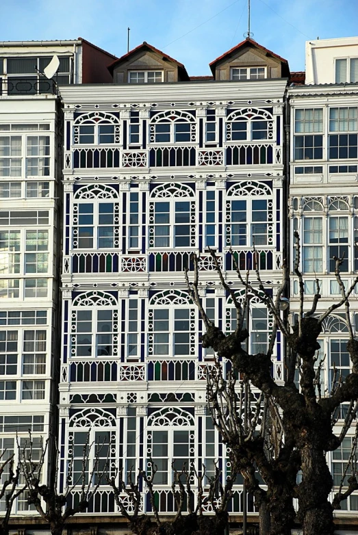 a white building and bare trees against a clear sky