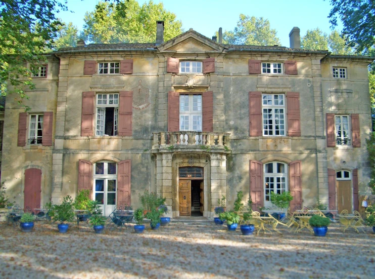 a big house with a lot of windows and potted plants