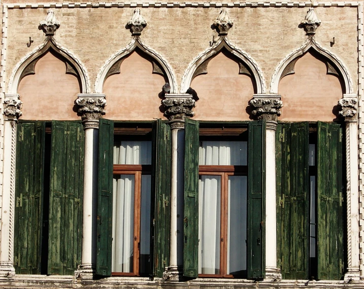 three green windows with tall windows with wooden accents