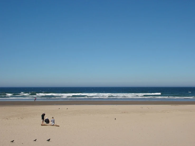 people are walking and riding the beach near the ocean