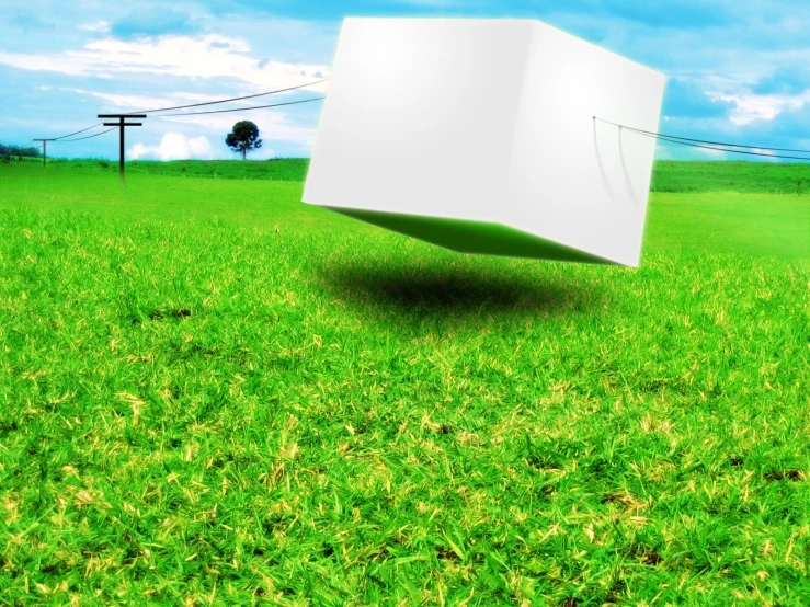 an empty cube in the grass with a sky in the background