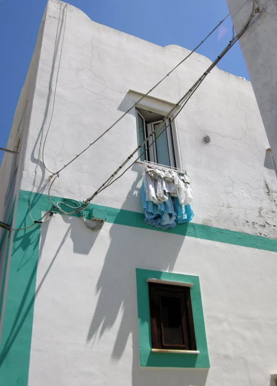 a window next to a green and white building