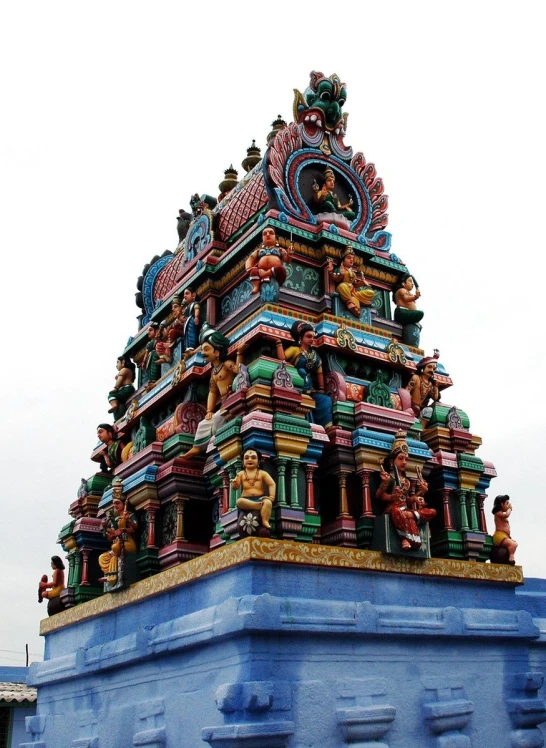 an intricate multicolored building in india against a cloudy sky