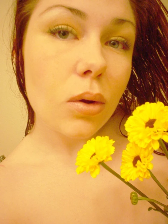 a woman holding flowers and looking at the camera