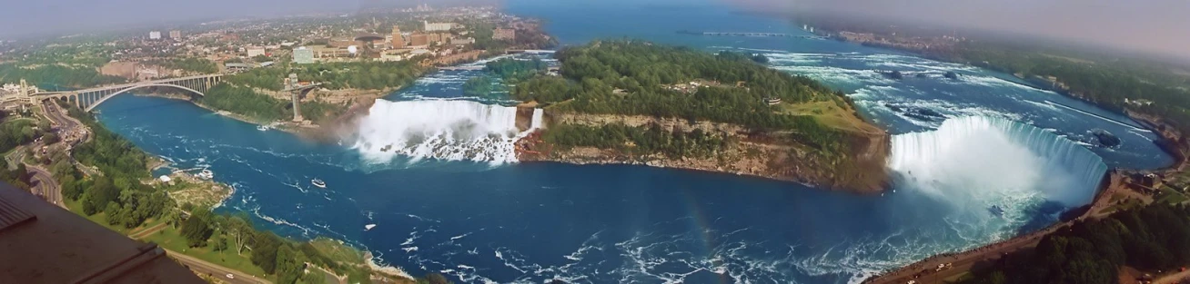 view from inside an airplane of water with bridge and city below