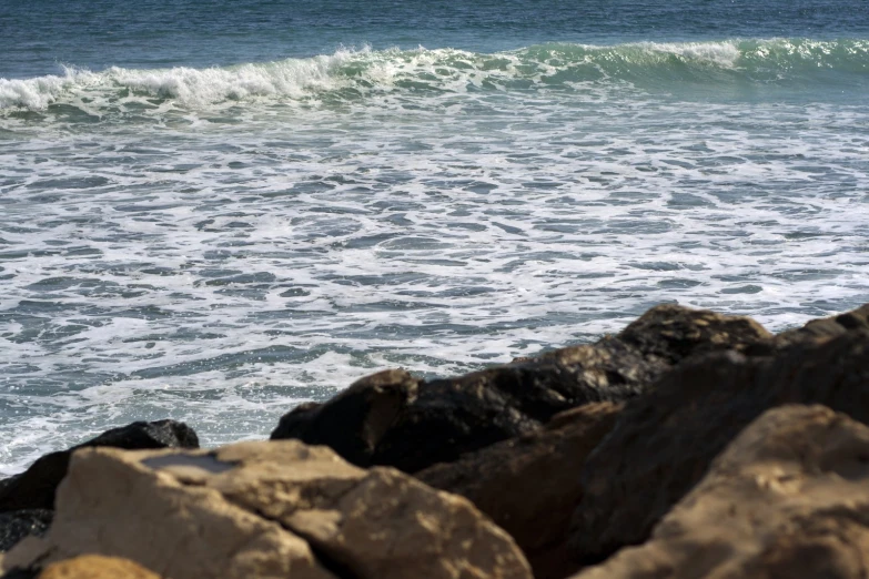 a man standing on the rocks watching a wave