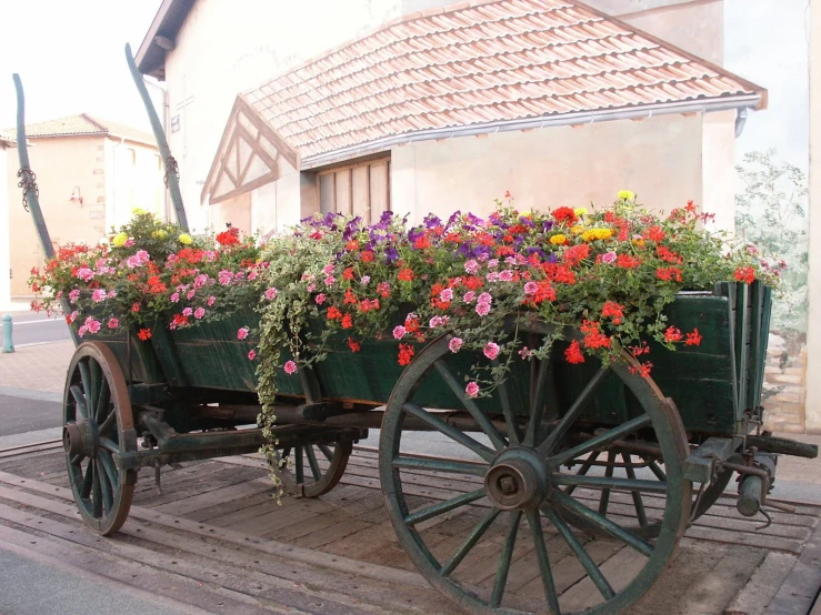 a green wagon with flowers growing out of the back