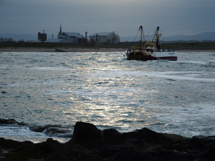 small boat in the distance on large ocean