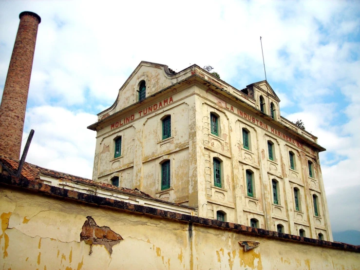 an old, dirty building sits in the distance near another building