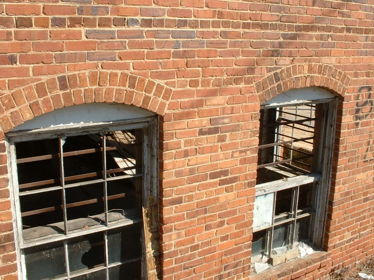 two windows in a brick building on the side of it