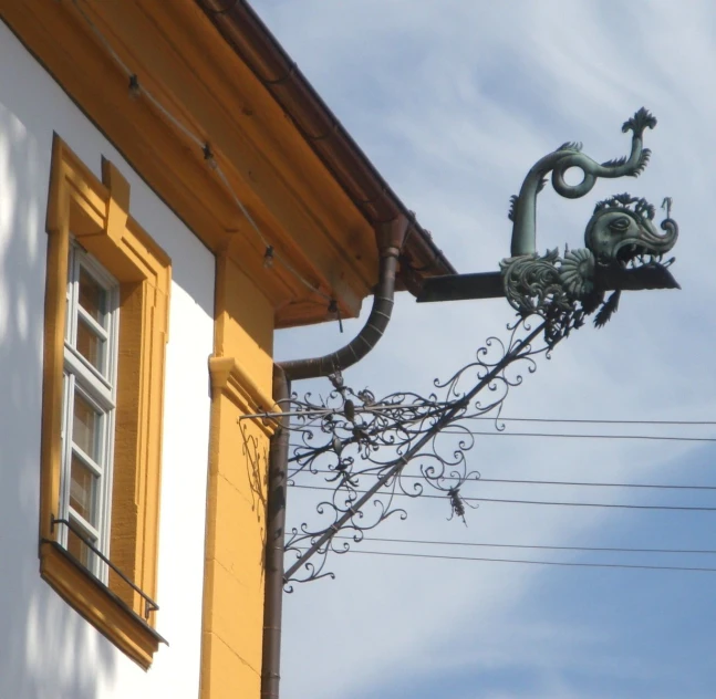 the metal street light is on top of the old building