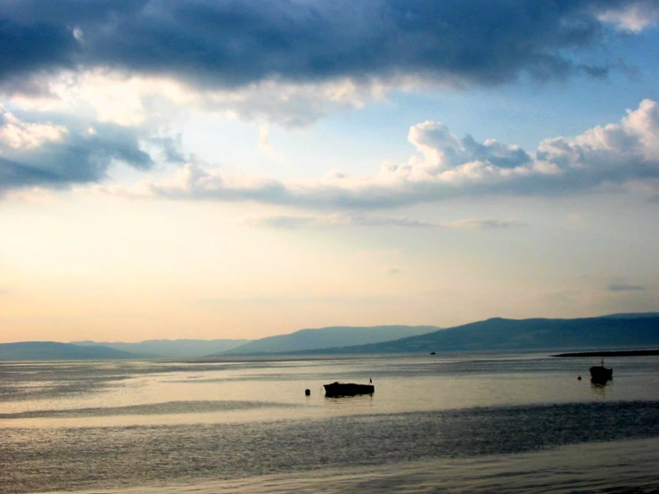 two long boats on the water near mountains