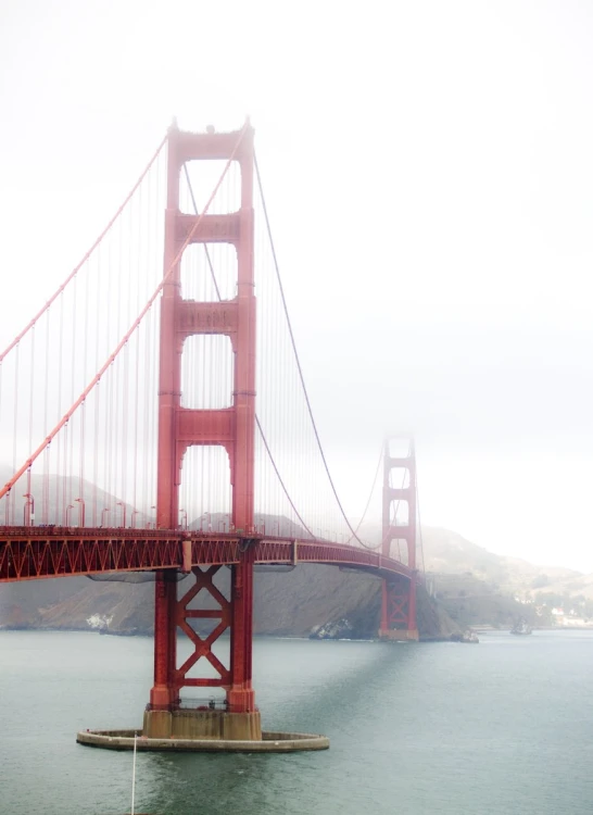 a tall red suspension bridge across the water