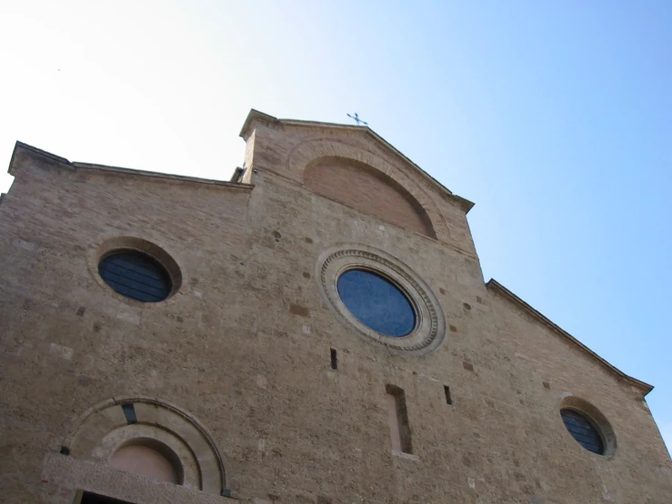 the church is tall and brown with round windows