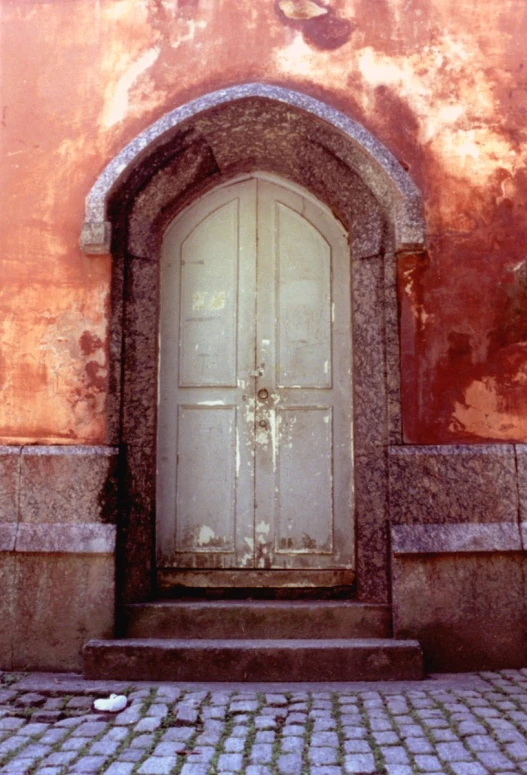 an open doorway with a stone walkway between two buildings