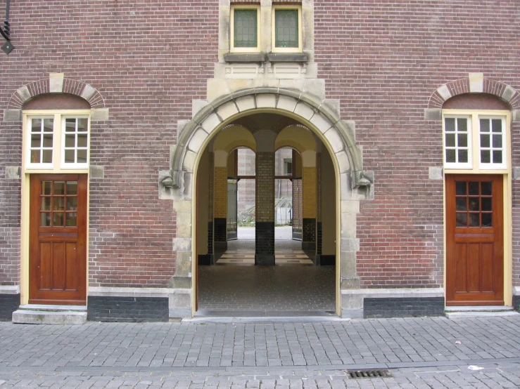 two wooden doors are open on the brick building