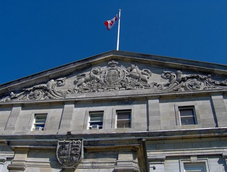 a tall stone building has a flag on top of it