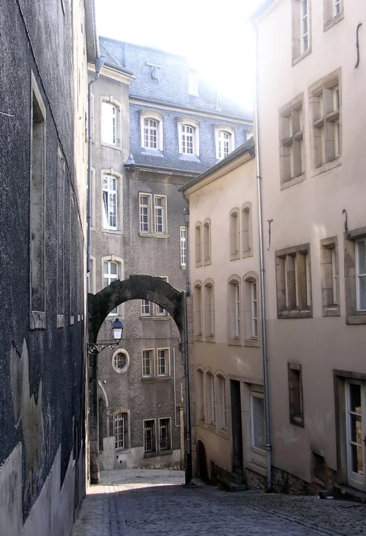 a narrow alley with stone archways and buildings
