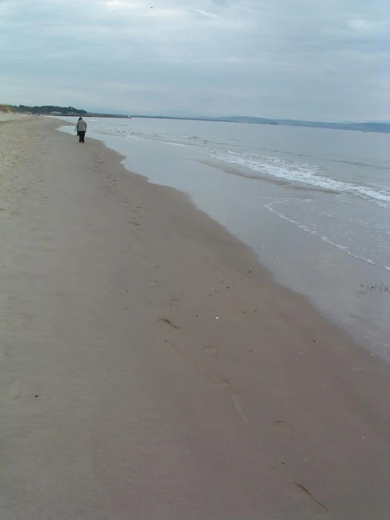 a person walking on the beach toward the ocean