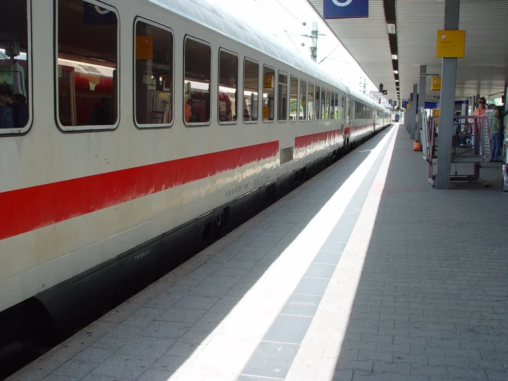 a train is pulled up to the station with people boarding