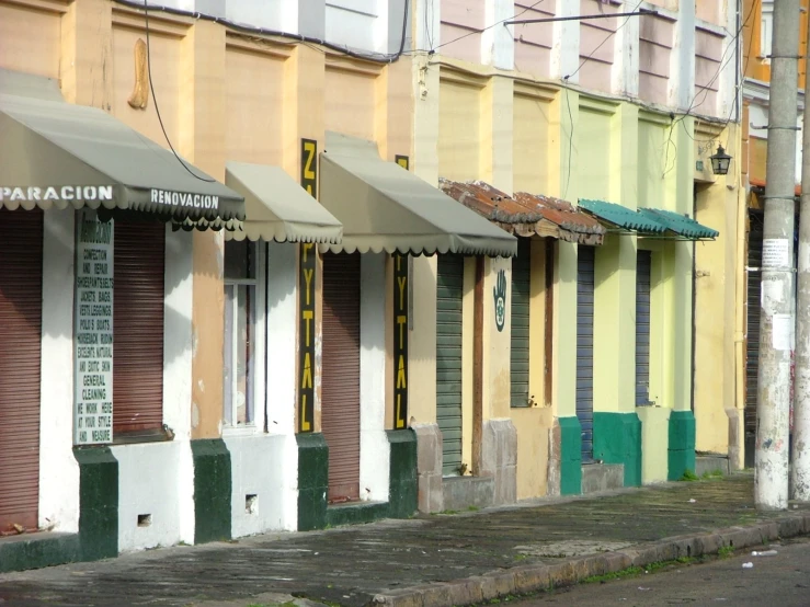 many colorful shutters line the sidewalk and curb of a residential building