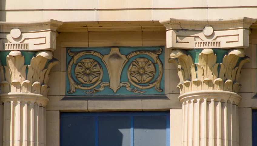 two elaborately decorated columns and window shutters on the side of a building