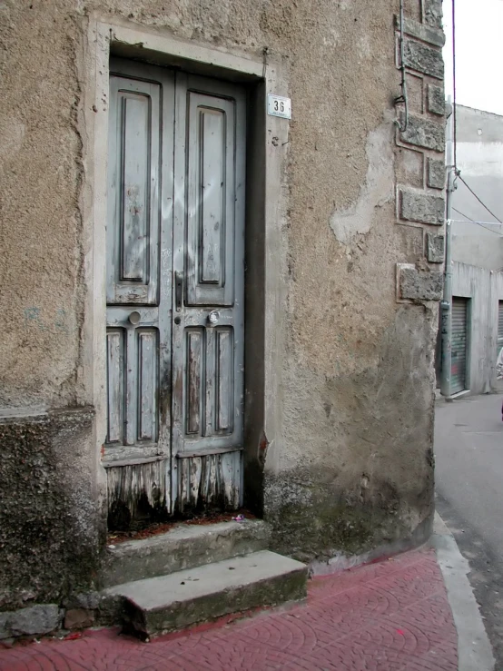 an empty street and building with a wooden door