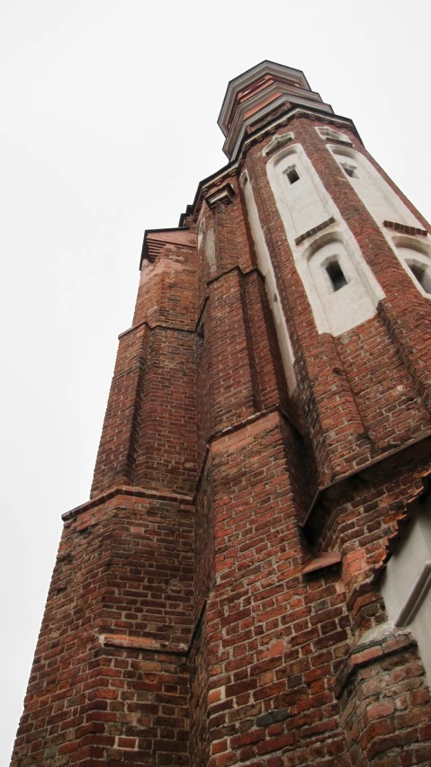 a tall brick clock tower with a sky background