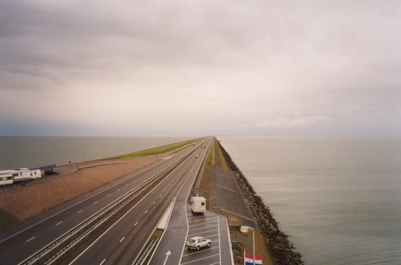 a cloudy sky and some cars on the road