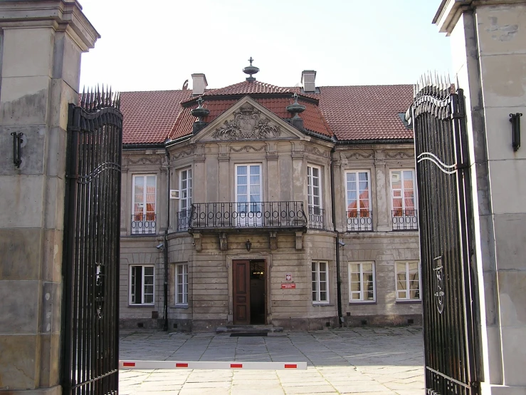 large brown building with gated entrance in front