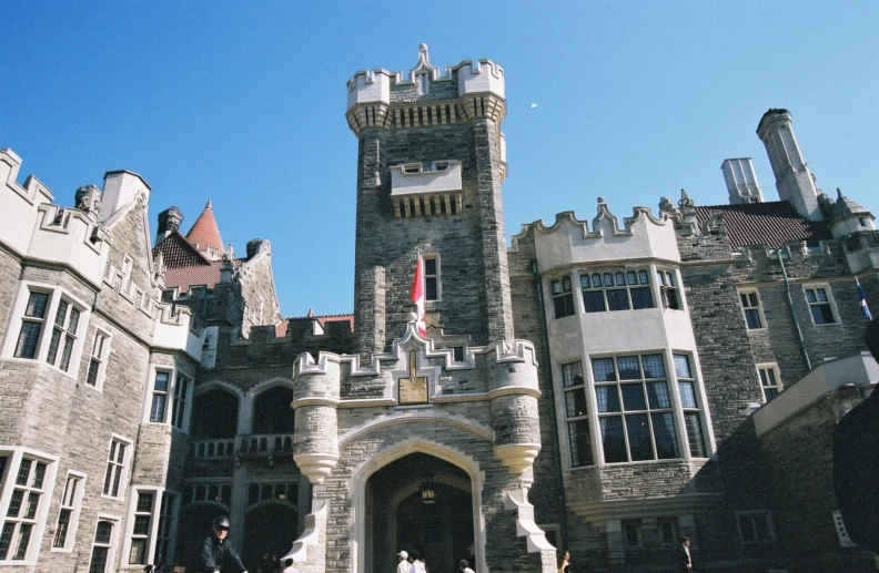 some people walking past an ancient castle like building