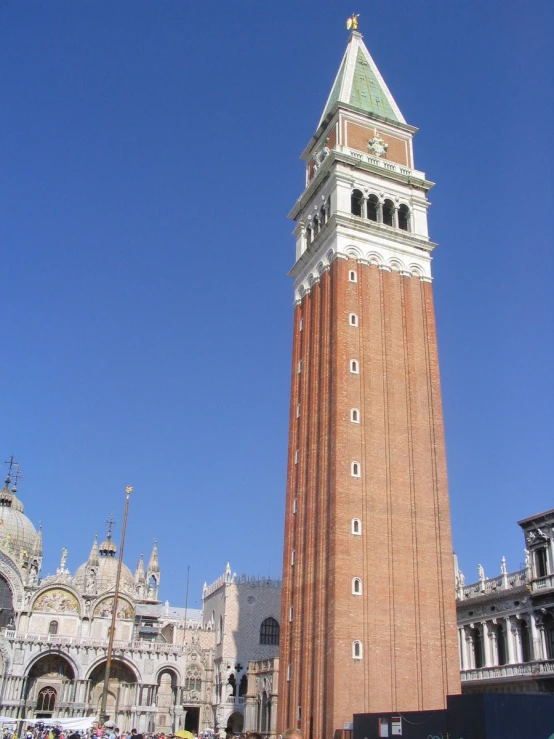 a tall brick clock tower is surrounded by others