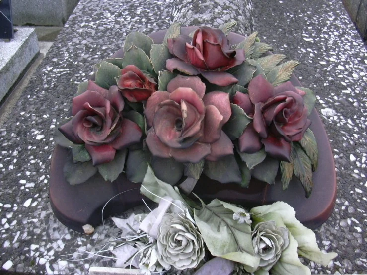 some fake flowers sitting on the top of a bench