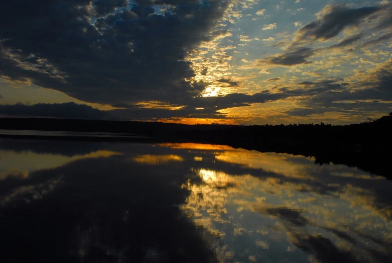 the sun setting over a large body of water