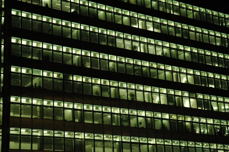 the facade of an office building is lit up at night