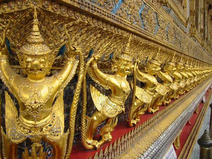 a lot of gilded gold statues with different designs on them