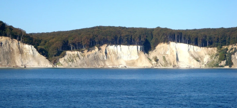 large cliff along the side of a lake
