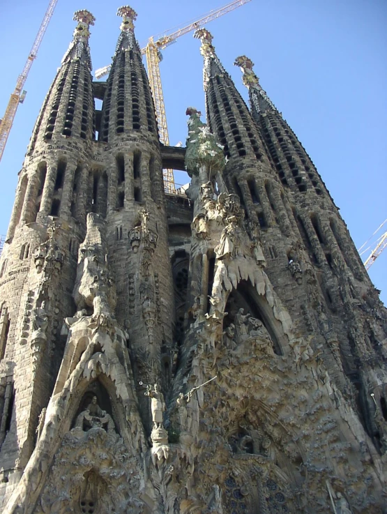 the large cathedral is under construction at the base of a crane