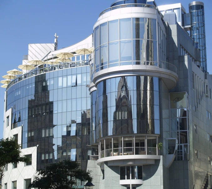 a building is reflecting a large glass building