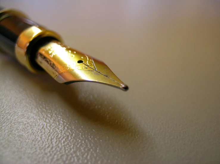 a gold - plated fountain pen with an ink dropper